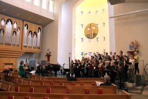 Kören - fina med sina gröna attiraljer - fyller Lundby nya kyrka med klang och jubel under genrepet.