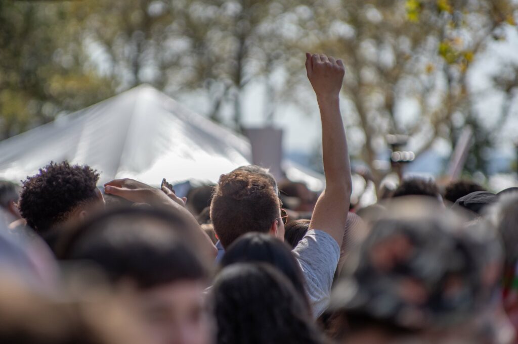 A man raising his fist in the air in a ocean of people 