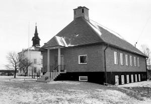 När det, 1958, bestämts att man ska riva den gamla kyrkan och bygga en ny så beslutar man först att bygga ett nytt församlingshus. Detta skall användas som kyrkolokal medan man river och bygger den nya kyrkan. 300.000kr anslås. Den 19 november 1961 står det klart.