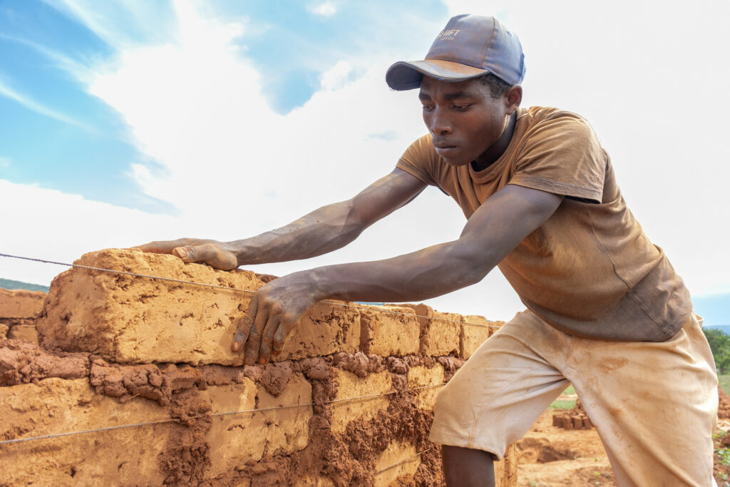 En man bygger en vägg med tegelstenar