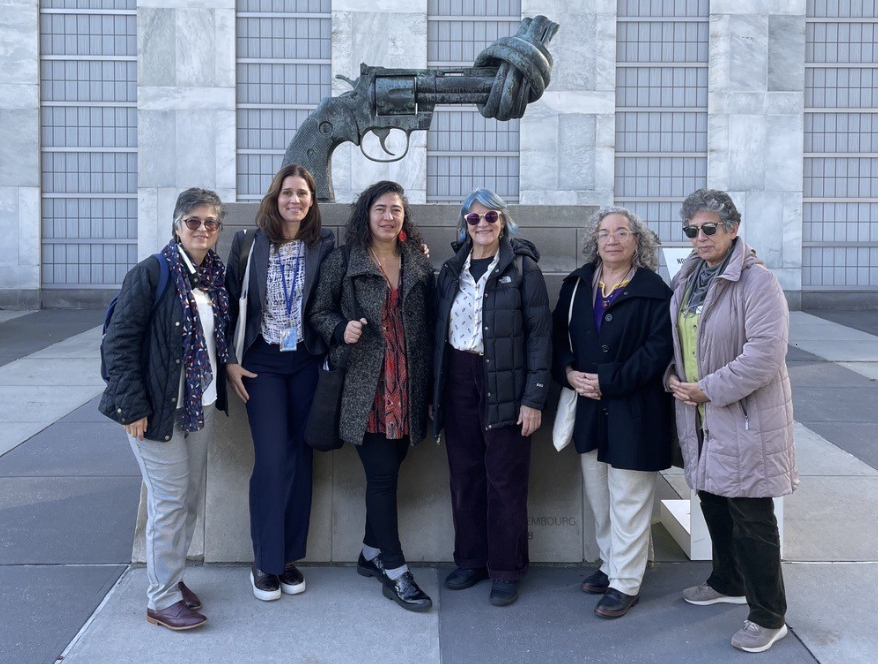 Kvinnor i grupp står framför en fredsstaty