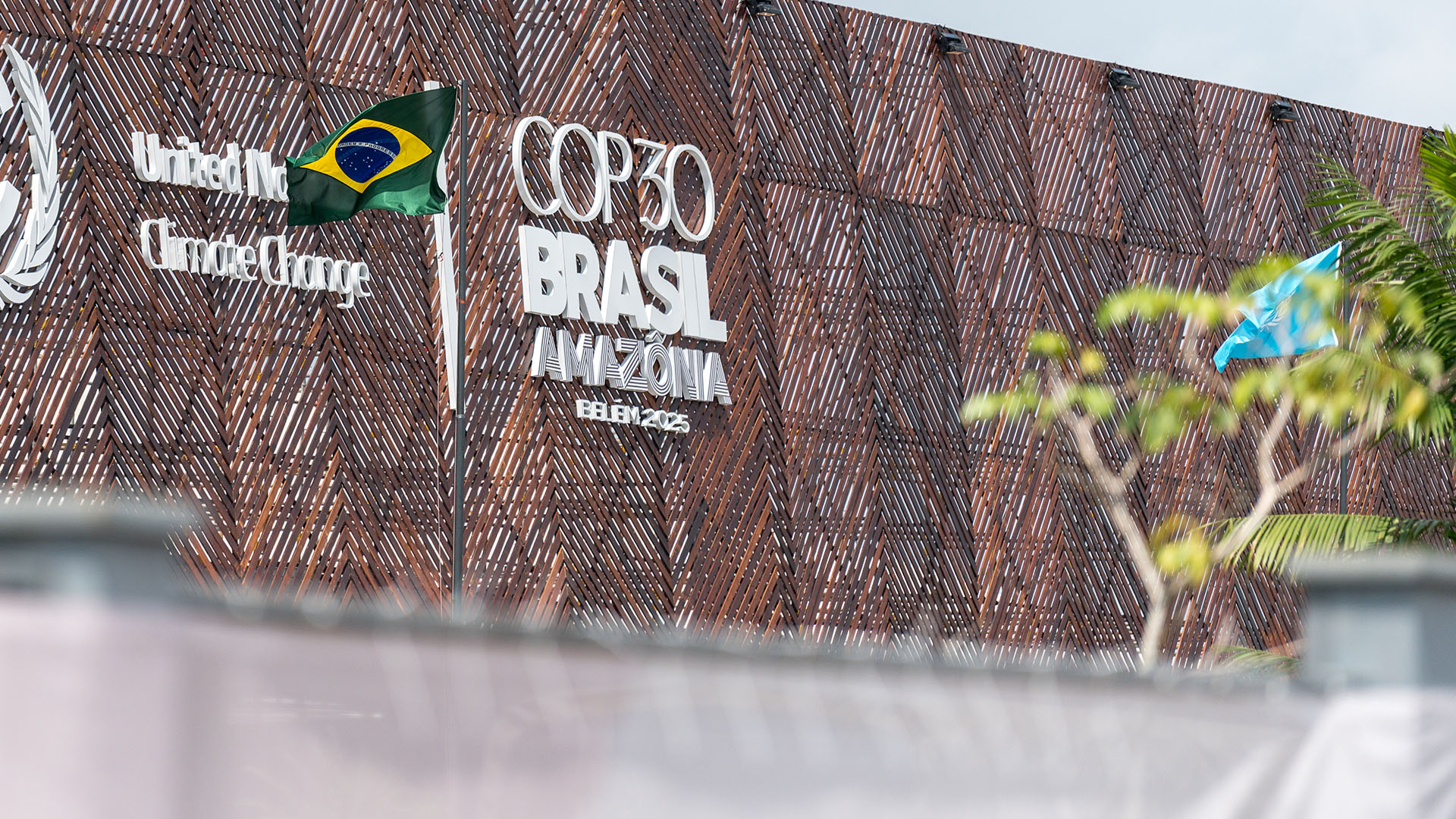 Byggnadsfasad med texten COP30, Brasil, Amazónia. På bilden syns också Brasiliens flagga.