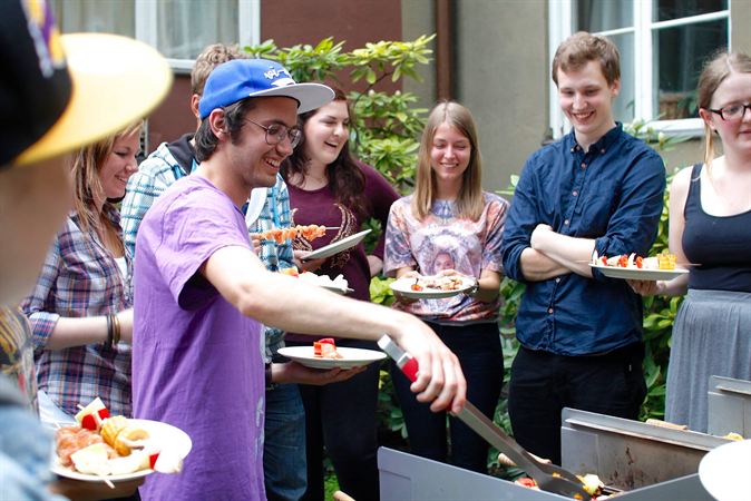 Foto på glada ungdomar som grillar.